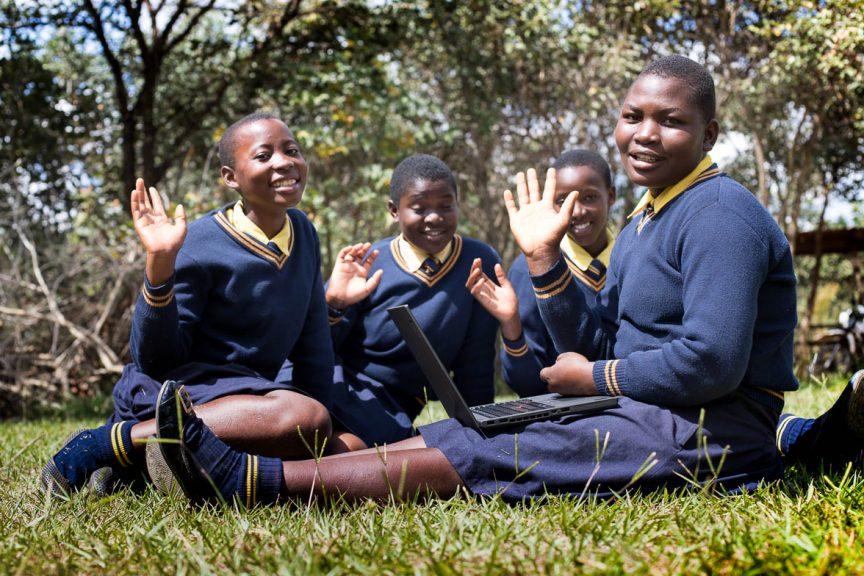 Feature Image shows Kuwala Campus Girls waving with new donated laptops