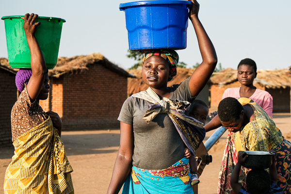 Image of village life. Girl carrying water from the village