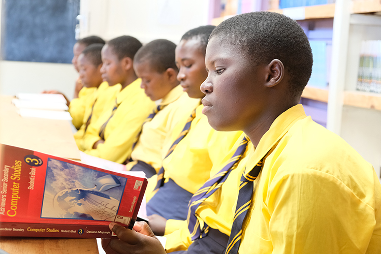 Image of Keliter a Kuwala student reading about computers.