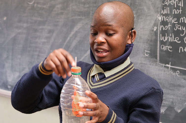 Khumba uses a model lung to show other students how lungs function.