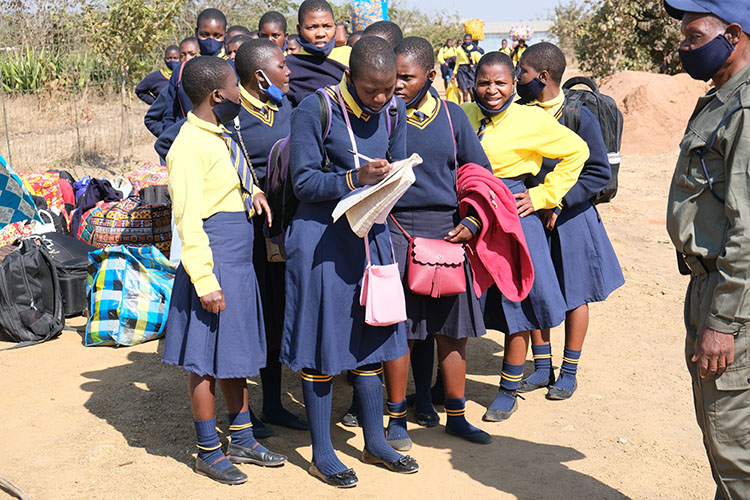 Kuwala students signing the checkout form with campus guard insuring all students sign out.