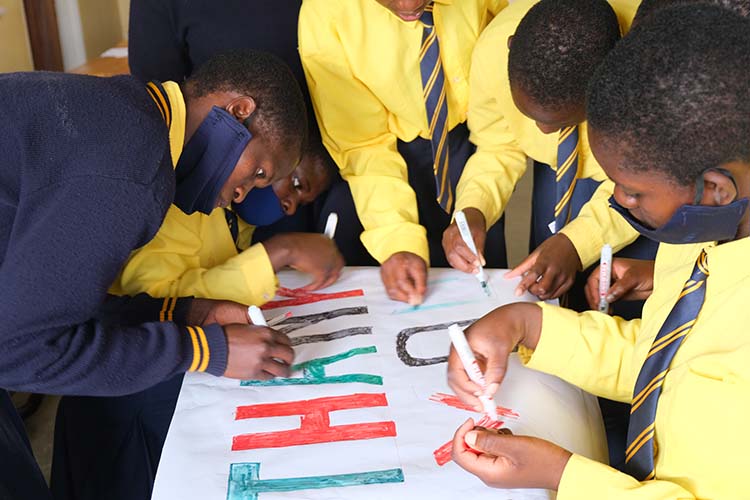 Students crafting the large thank you card for Canada.