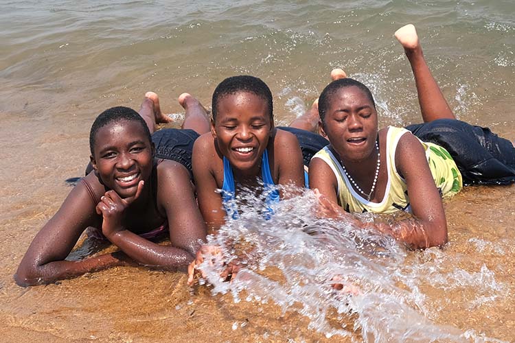 Kuwala girls laying at the water's edge at Savannah Beach.