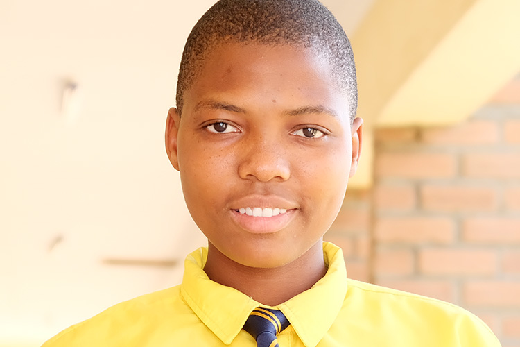 Close up of Kuwala Student Desire in school uniform with tie and yellow dress shirt.