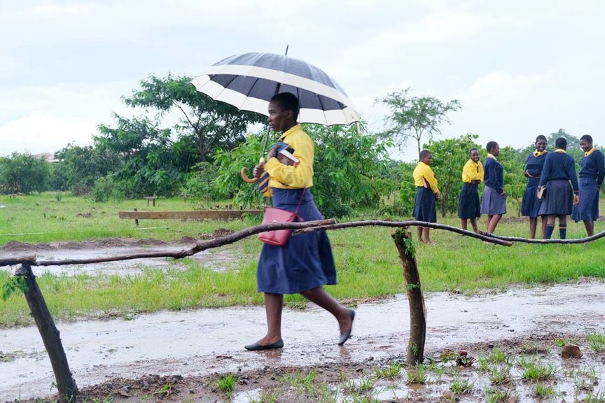 Kuwala student with umbrella walking in the rain.