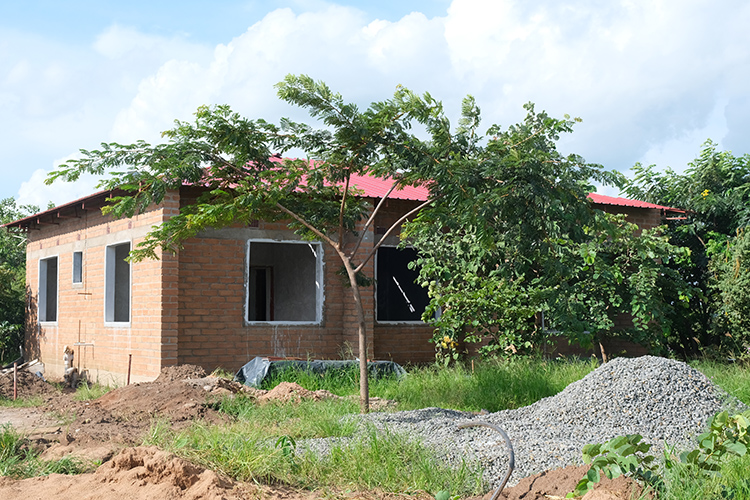 Exterior of second staff house. Steel roof is complete house shown with missing windows