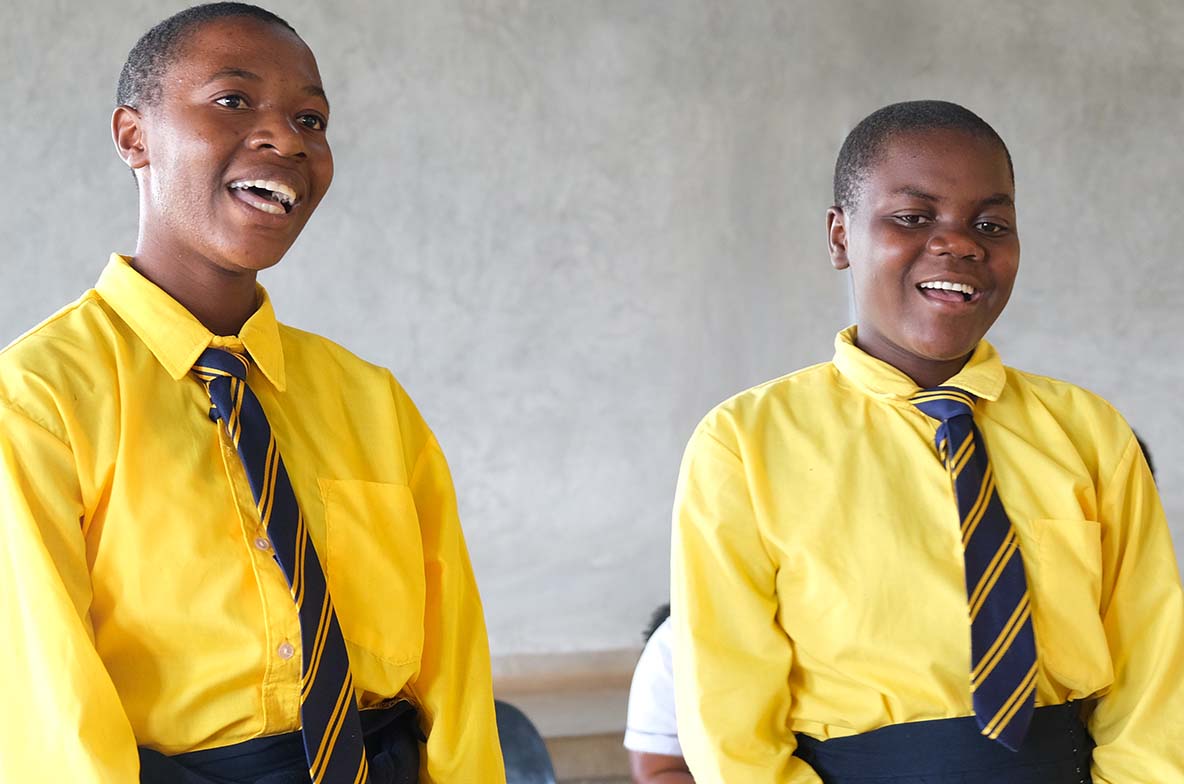 Two Kuwala students singing in their school uniforms