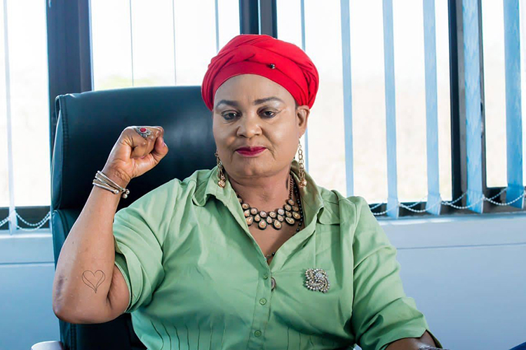 Malawi Minister of Gender, Community, and Social Welfare Patricia Kaliati seating at a desk showing a fist pump.