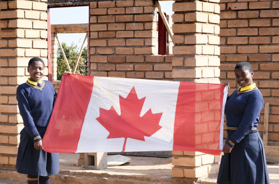Students showing a Canadian flag as the metaphoric symbol of the Canadian and Malawian partnership.