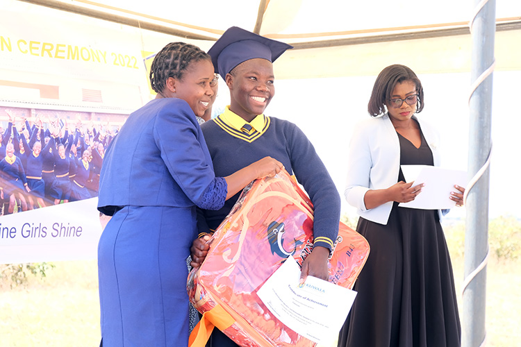 Memory Mdyetseni and student Tamanda posing for a photograph with student award blanket. 