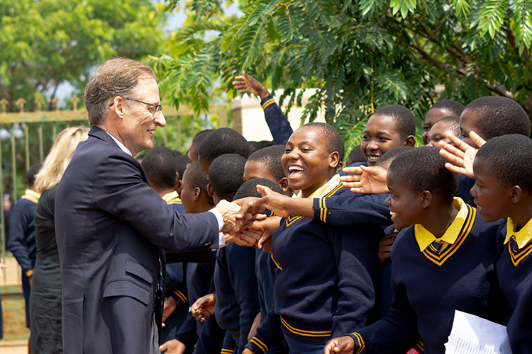 Mark Kinzel shaking hands with a crowd of Kuwala Students.