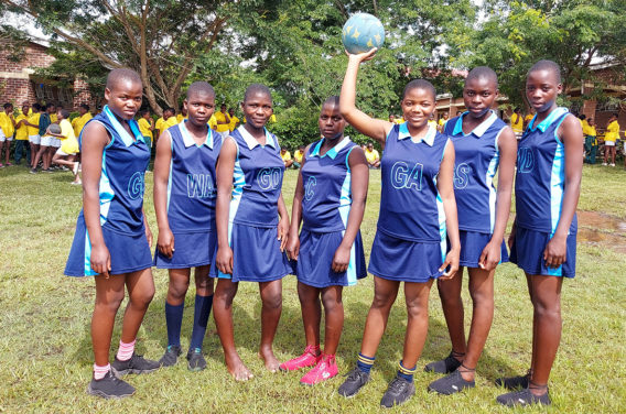 Kuwala Netball team with centre student holding ball above her head.