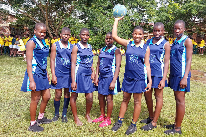 Kuwala Netball team with centre student holding ball above her head.
