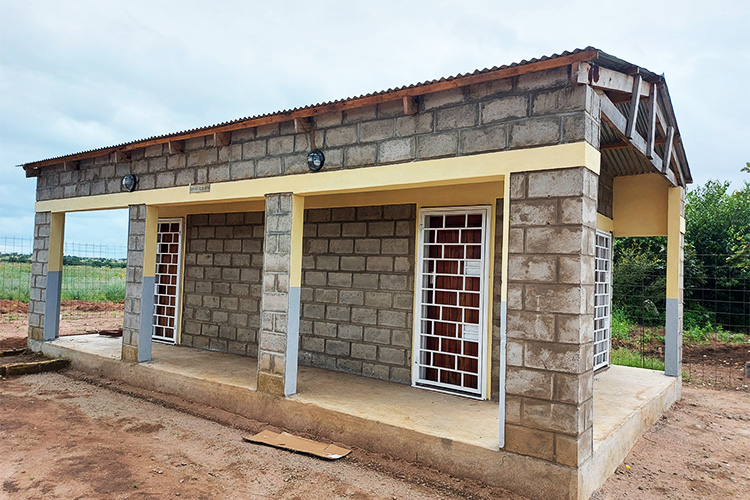 Outside the the maize mill showing the completed cinder block with concrete base construction.