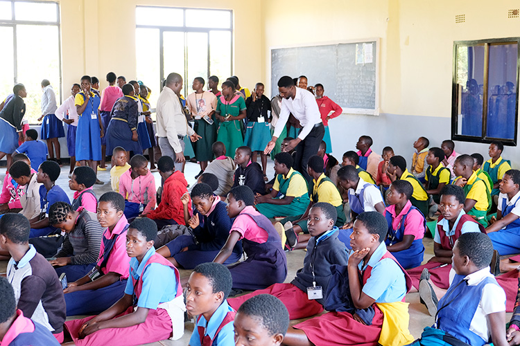 Student candidates seating on the floor waiting to write their entrance exams. 