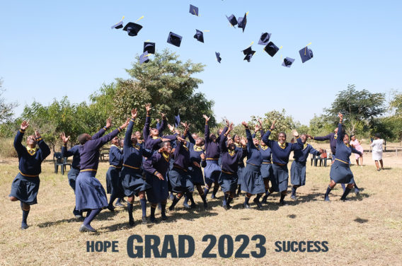 Kuwala students outside throwing their grad caps in the air