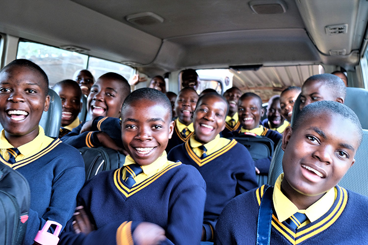 Kuwala students smiling on roadtrip in van.