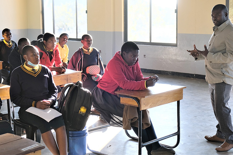 Kuwala students seating behind desks in the classroom block.