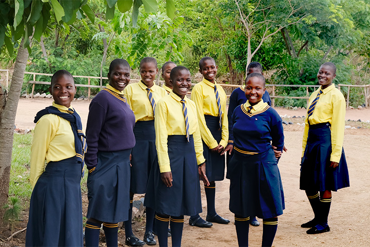 Group of Kuwala students standing outside under a tree at the Campus.