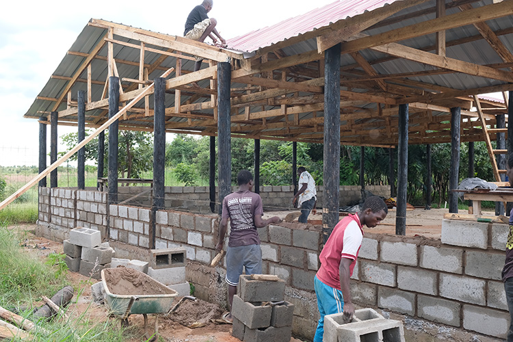 Workers laying cinder blocks for the main wall of the Workshop. 