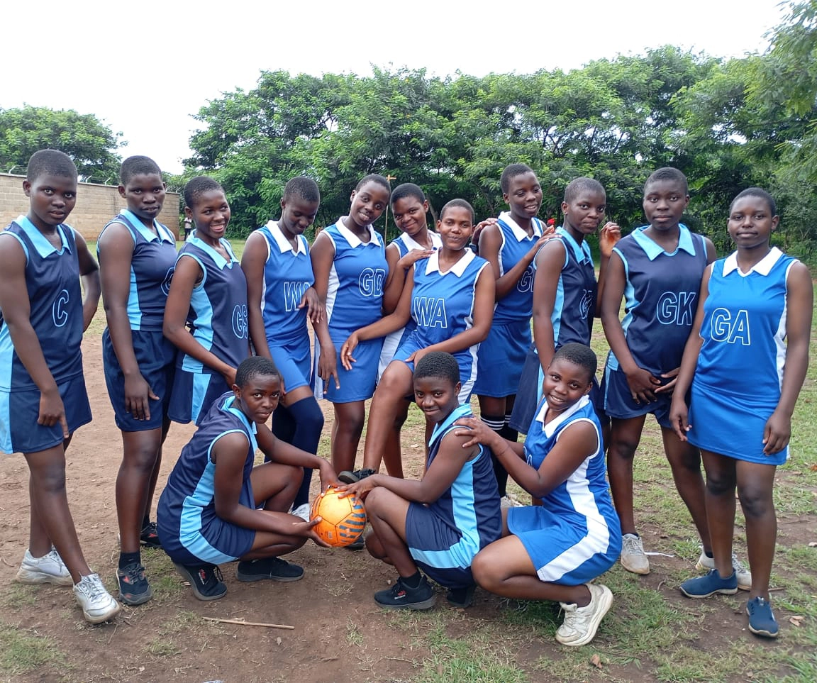 Kuwala girls posing for a Netball group photo.