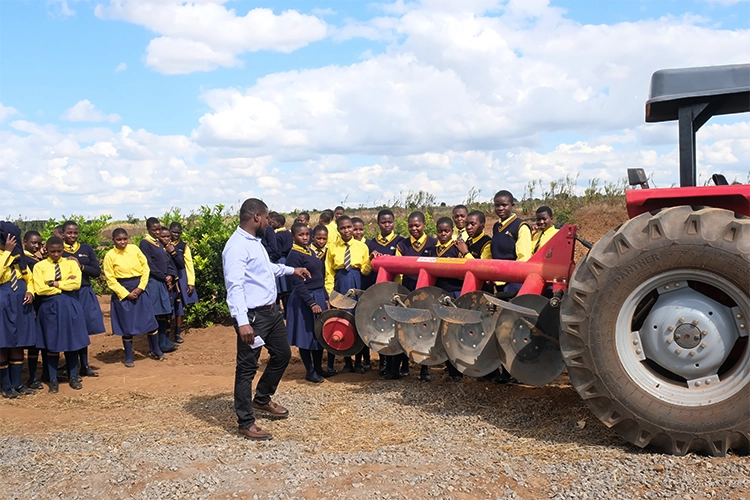 Teacher is showing the students how a power take off is used with an blade disc attachment.