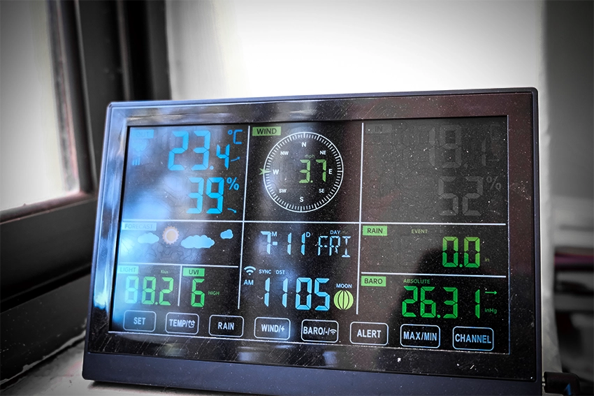 Remote display screen showing temperature, wind speed, date, time, barometric pressure, light and UV levels, and rain event.