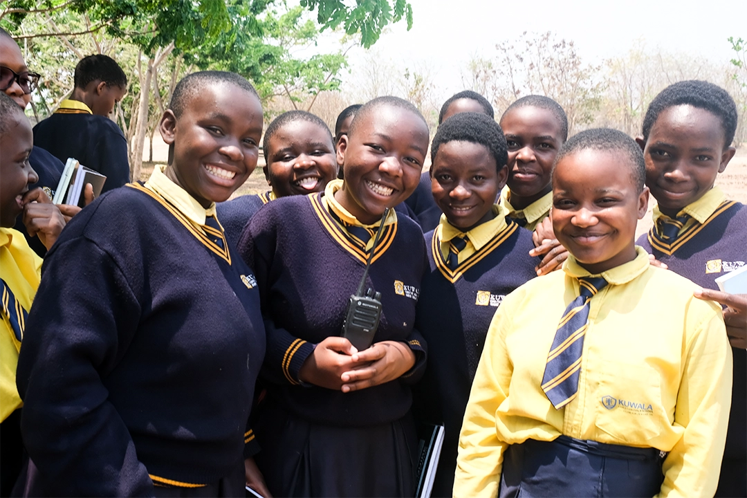 Grouping of Kuwala Students smiling outside.
