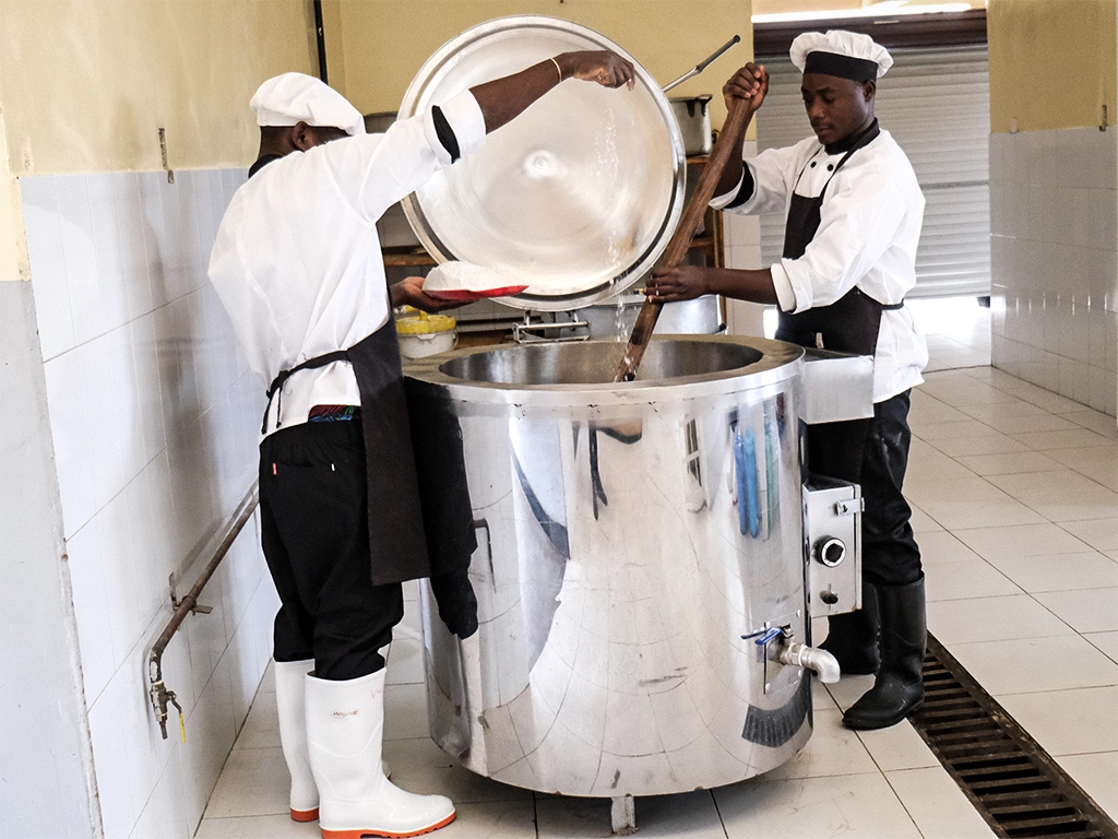 Kuwala cooks stirring the oil jacketed pot.